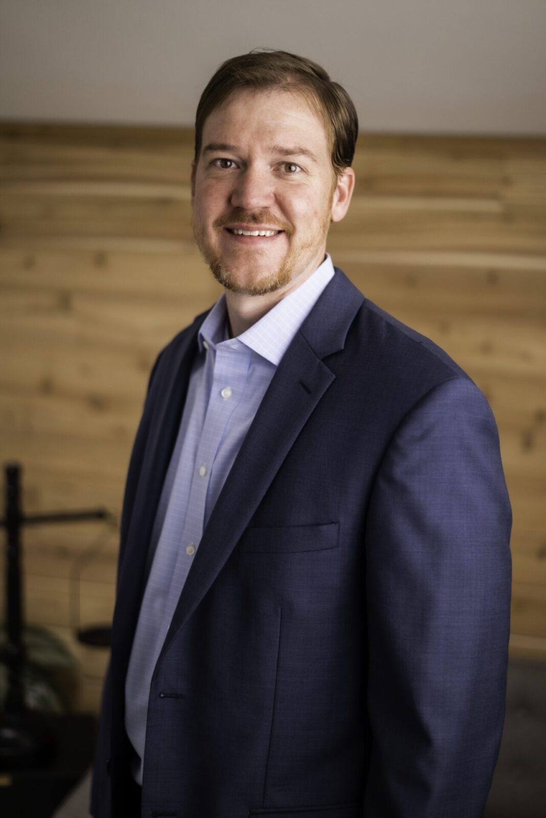 Picture of Brian young smiling on a wood grain background